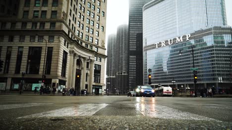 Los-Autos-Esperan-En-El-Semáforo-En-Rojo-Mientras-La-Gente-Cruza-Un-Paso-De-Peatones-En-La-Niebla-De-Chicago-En-Una-Milla-Magnífica-Entre-La-Arquitectura-Antigua-Y-Moderna-Con-El-Hotel-Trump-Al-Fondo