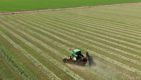 Aerial-shot-of-tractor-pulling-harrows-in-Imperial,-California