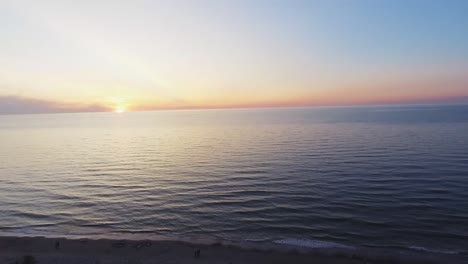 4k-aerial-footage-of-an-idyllic-beach-at-the-baltic-sea-in-Poland,-where-unrecogizable-people-take-a-walk