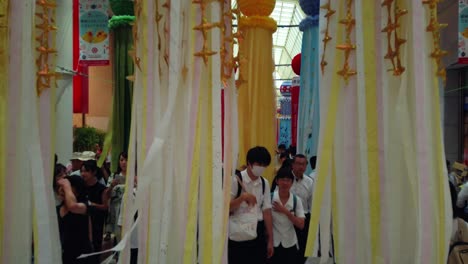 Menschen-In-Spielhallen,-Die-Während-Des-Tanabata-Festivals-Durch-Dekorative-Papierschlangen-Laufen