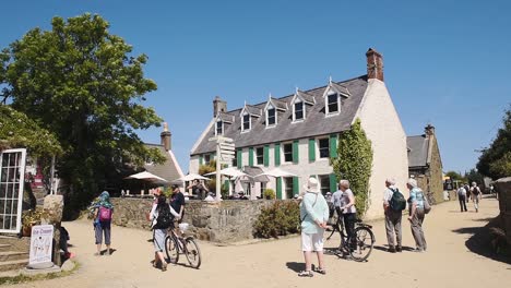 Menschen-Gehen-An-Einem-Sonnigen-Sommertag-Auf-Der-Unbefestigten-Straße-Mit-Altem-Haus-In-Sark,-Kanalinseln,-Großbritannien,-Spazieren