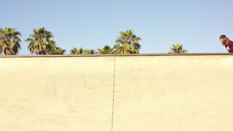 Zeitlupe-Eines-Mannes-Mit-Baseballkappe,-Der-An-Der-Seite-Der-Skatepark-Schüssel-Entlanggleitet-Und-Dabei-Schatten-Auf-Die-Wand-Wirft