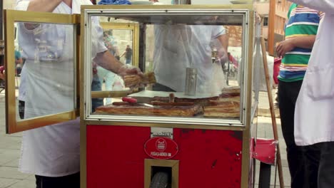 Streetfood-Wagen-In-Istanbul-Mit-Verkäufer,-Der-Ein-Stück-Borek-Für-Den-Kunden-Schneidet