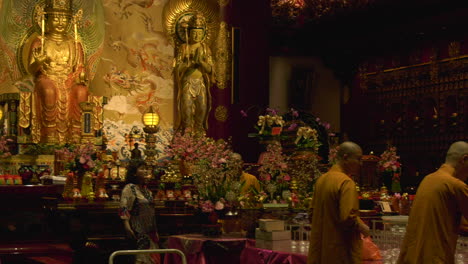 Monks-filling-up-a-bucket-of-rice-in-a-temple-in-Chinatown,-Singapore