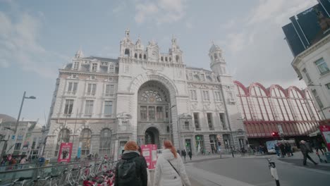 Junge-Frauen-Nähern-Sich-Dem-Antwerpener-Hauptbahnhof,-Vorbei-An-Leihfahrrädern