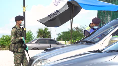 Military-Man-in-Camo-Stands-Guard-While-Police-Perform-a-Check-Point