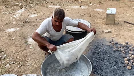 man-making-litti-in-the-traditional-way-and-shaking-off-the-ashes-from-cow-dung-on-the-ground