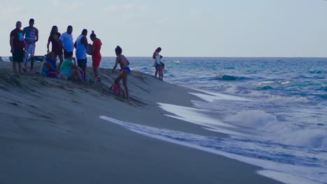 Eine-Gruppe-Von-Menschen-Sitzt-Und-Entspannt-Sich-Mit-Den-Wellen-Des-Strandes