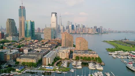 Dolly-Lateral-Aéreo-Del-Puerto-Deportivo-En-Jersey-City-Con-El-Horizonte-De-Manhattan-Al-Atardecer