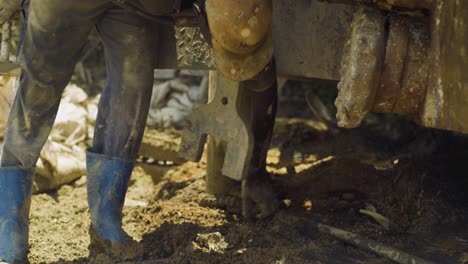 Primer-Plano-De-Un-Constructor-Perforando-Una-Nueva-Fuente-En-Uganda-Con-Botas-De-Goma-Azules