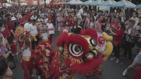 Chinese-New-Year-celebrating-in-Chinatown-Bangkok,-Thailand---traditional-Dragon-dance-on-the-street---People-wearing-masks-because-of-the-new-corona-virus-outbreak---Editorial