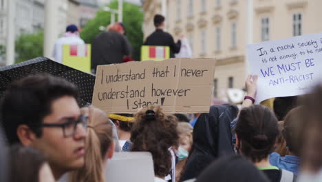 A-close-slow-motion-shot-with-a-nice-depth-of-field-showing-a-demonstration-sign-against-racism