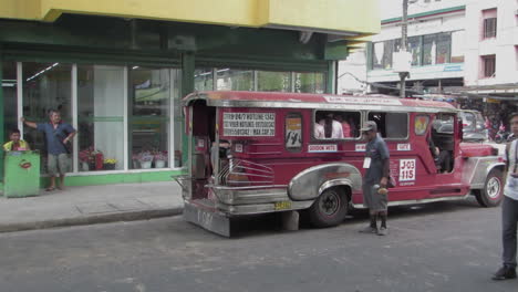 Red-Iconic-jeepney-departing-with-passengers-in-Olongapo-City,-Zambales,-Philippines