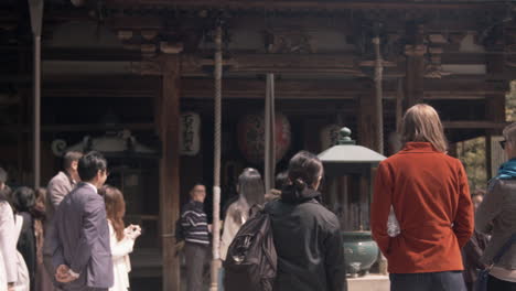 Group-of-tourists-at-entrance-to-ancient-temple,-Kyoto,-Japan