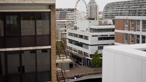 Zeitraffer-Einer-Gruppe-Herumhängender-Teenager-Und-Ein-Schöner-Blick-Auf-Ein-Riesenrad-Im-Hintergrund,-Umgeben-Von-Architektur