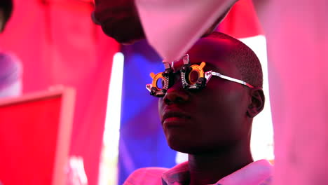 An-eye-technician-changes-a-patient's-lens-during-an-eyesight-screening-in-a-mobile-medical-clinic-in-Machakos,-Kenya