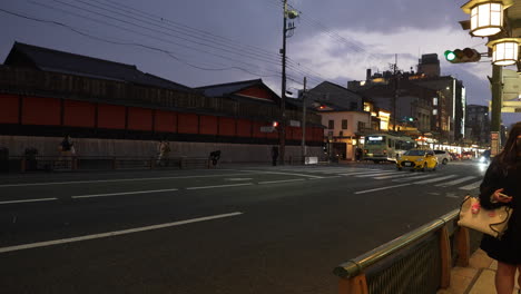 Shot-of-Japanese-street-atmosphere,-people-and-buildings-in-the-city-of-Osaka-during-a-snowfall-at-night