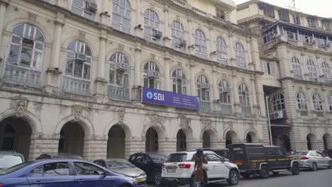 Parking-area-behind-the-State-Bank-of-India-iconic-and-historical-building-with-brand-hoarding-in-Horniman-Circle,-South-Mumbai,-India