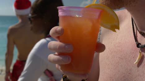 Persona-Bebiendo-Un-Ponche-De-Ron-Fresco-En-La-Playa-Del-Avión-Caribeño-Mahoa-En-Vísperas-De-Navidad