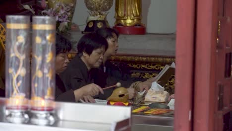 Weibliche-Chinesische-Buddhistische-Mönche-Beten-Im-Tempel-Und-Spielen-Holzfische