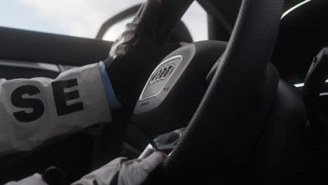 Cerca-De-La-Mano-Femenina-En-El-Volante-De-Un-Coche-Audi