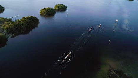 Aerial-Follow-Behind-Shot-of-Rowing-Crew-at-Sunset