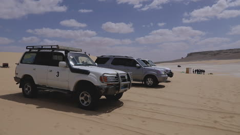 Autos-De-Campamento-Estacionados-En-La-Arena-Bajo-Un-Cielo-Nublado-En-El-Desierto---Panorámica-Hacia-La-Derecha