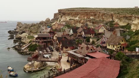 Vista-Del-Pueblo-En-Un-Día-Ventoso-Y-Nublado-Con-Turistas-Caminando