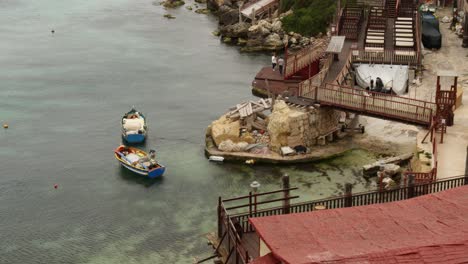 Zwei-Boote-Im-Meer-Und-Menschen,-Die-Auf-Dem-Pier-Spazieren