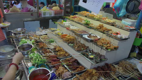 Gran-Exhibición-De-Brochetas-De-Carne,-Gente-Comprando-Y-Recogiendo-Comida-Callejera,-Mercado-Nocturno,-Malasia