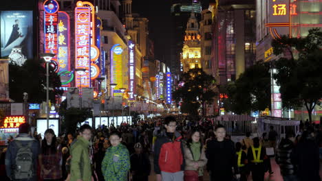 Llena-De-Gente-Con-Luces-De-Neón-En-La-Carretera-De-Nanjing-Por-La-Noche,-Shanghai-4k