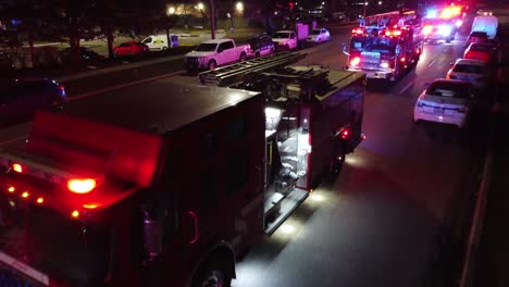 Antena-De-Primer-Plano-Del-Camión-De-Bomberos-Ems-Parpadeando-Luces-Azules-Rojas-Por-La-Noche,-Bandeja-De-Transporte