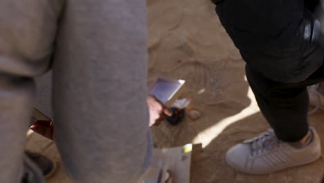 A-group-of-men-trying-to-make-fires-in-the-desert--low-angle