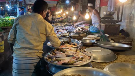 Eine-Gruppe-Von-Fischhändlern,-Die-Frische-Meeresfrüchte-Auf-Dem-Fischmarkt-Verkaufen