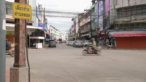 Toma-De-Movimiento-De-Automóviles-A-Lo-Largo-Del-Cruce-De-Carreteras-En-La-Ciudad-De-Nan,-Tailandia,-En-Un-Día-Nublado