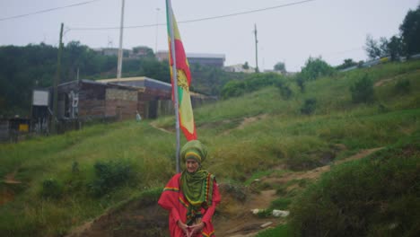 Kaukasische-Rastafari-Frau-Steht-Hinter-Der-Rastafari-Flagge-Am-Juda-Square