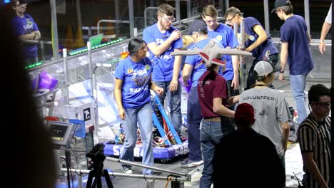 Estudiantes-Colocando-Sus-Robots-En-El-Campo-De-Juego-Antes-De-Un-Partido-En-La-Primera-Robótica