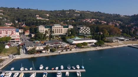 Drone-forward-flying-over-ship-docking-area-in-Trieste-towards-Kempinski-palace-hotel