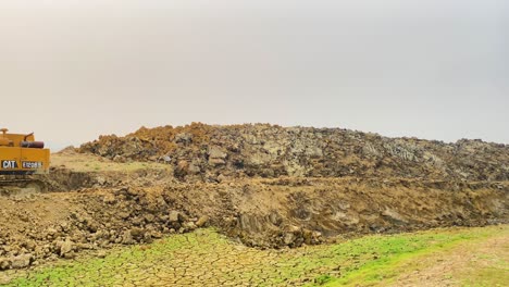 Yellow-excavator-on-digged-up-dry-land