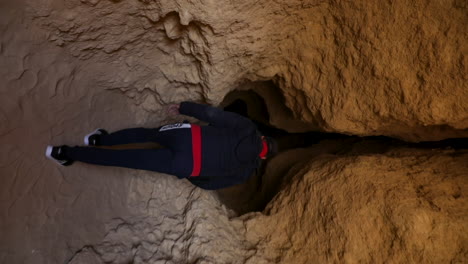 The-campers-entering-a-gap-inside-the-mountain-in-the-desert-of-Egypt---vertical-video