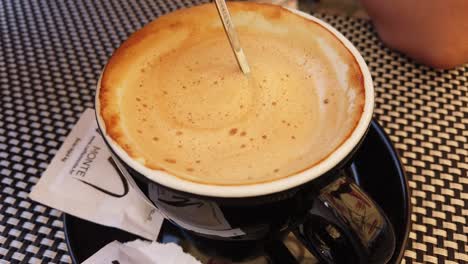 Close-up-of-a-cup-of-coffee-stirred-with-a-small-spoon