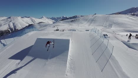 Aerial-View-of-Freestyle-Ski-Jumper-Making-Flips-and-Twists-From-Kickers,-FPV-Drone-Shot-50fps