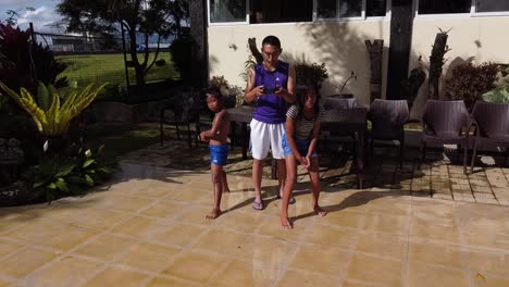 A-rearward-aerial-shot-of-two-kids-running-and-jumping-into-the-pool