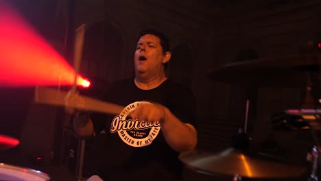 Cinematic-shot-of-a-drummer-playing-during-a-concert-with-bright-stage-lights