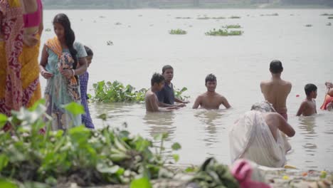 Hombres-Y-Mujeres-Indios-Bañándose-Y-Disfrutando-En-La-Orilla-Del-Río-Ganga-En-Verano,-Rani-Rashmoni-Ghat,-Cámara-Lenta