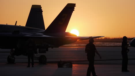 Silhouette-Eines-Marineoffiziers,-Der-Vor-Einem-Blauen-Engel-Auf-Dem-Rollfeld-Läuft,-Während-Die-Jets-Für-Eine-Flugshow-Am-Frühen-Morgen-Bei-Sonnenaufgang-In-Key-West-Vorbereitet-Werden