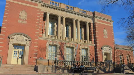 The-Public-Library-Of-Brookline-With-People-Sitting-On-The-Benches-In-Boston-Suburbs,-Brookline,-MA,-United-States