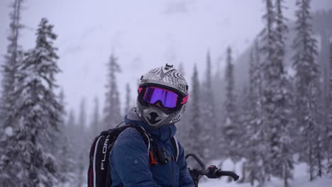 Hombre-Con-Casco-Y-Visera-Girando-La-Cabeza-En-Cámara-Lenta-Con-Un-Paisaje-Invernal-Detrás