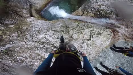 A-man-standing-at-the-edge-of-a-drop-with-a-waterfall