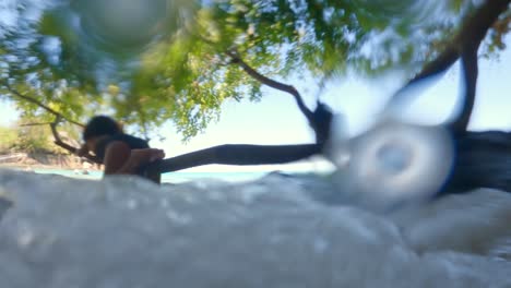 Hijas-En-Un-Brunch-En-Un-árbol-Mirando-Las-Olas-Pasando-Debajo-De-Ellas,-Mahe-Seychelles-Cámara-Lenta